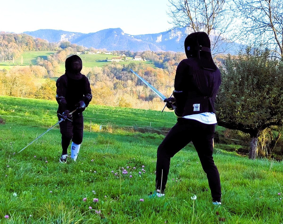 Deux escrimeurs en garde dans un pré
